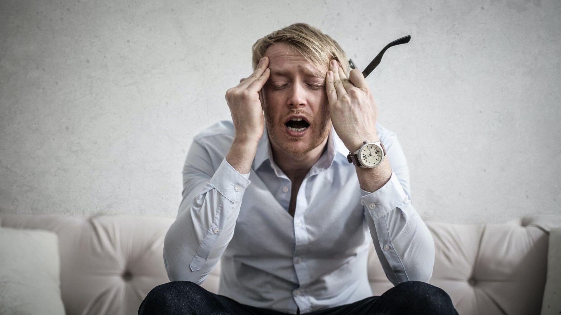 Moški z glavobolom zaradi stresa.